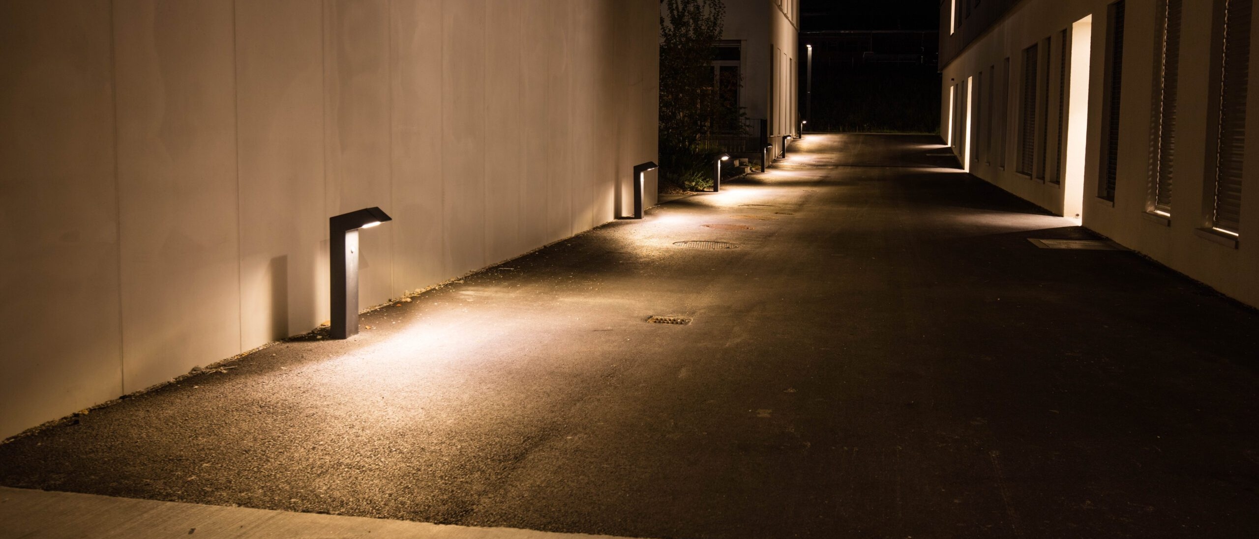 Borne Kassio illuminant une allée de nuit.